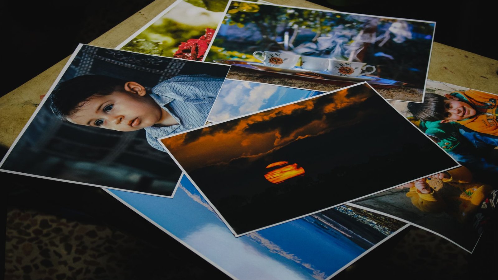 Printed holiday photos spread across a table before choosing a photo collage layout