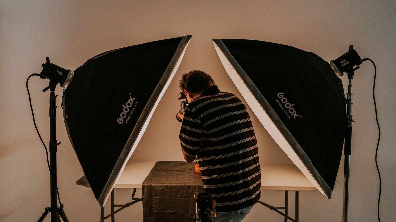 Photographer shooting a product on a bright table, the kind of original image SEO work Google rewards
