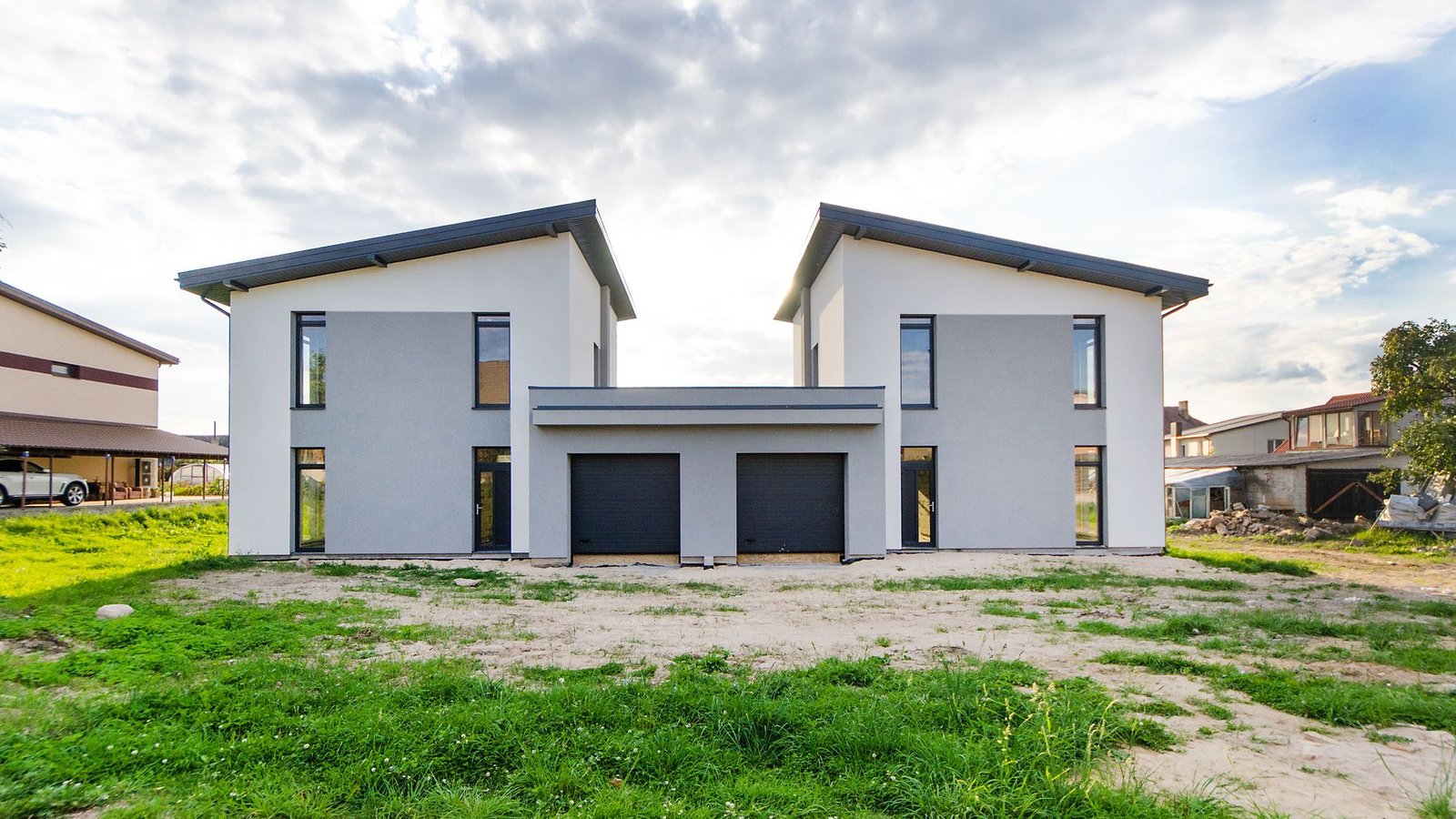 A newly built white house photographed square-on under a bright cloudy sky, the exterior hero shot a printed listing flyer is built around